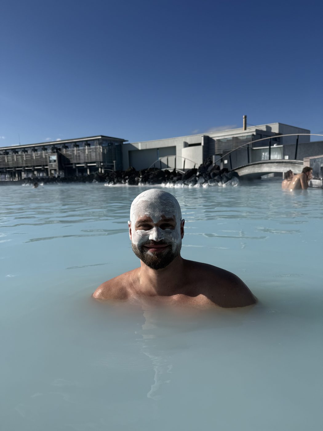 Smiling in the Blue Lagoon in Iceland, silica mask on, sun out