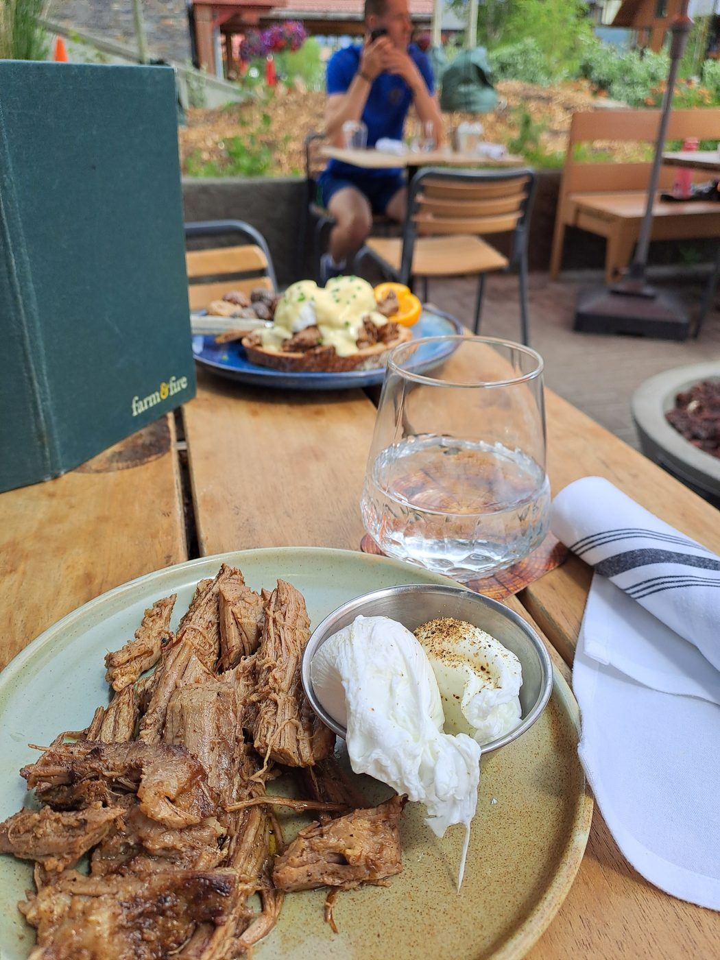 A plate of shredded bison meat with poached eggs at an outdoor restaurant in the Canadian mountains