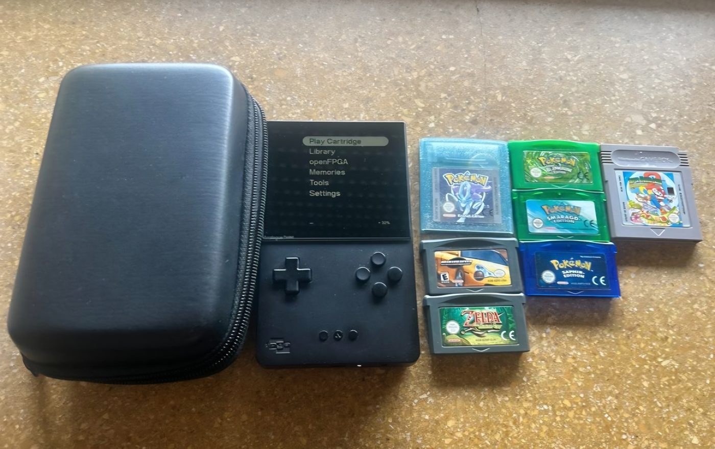 An Analogue Pocket handheld with a case and a row of original Game Boy and Game Boy Advance cartridges