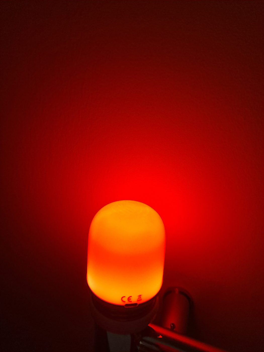A small red night bulb glowing softly in a dark room